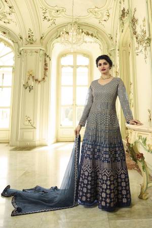 Flaunr Your Rich And Elegant Taste With This Heavy Designer Floor Length Suit In Grey And Blue Color Paired With Blue Colored Bottom And Grey And Blue Colored Dupatta. Its Heavy Embroidered Top Is Fabricated On Net Paired With Santoon Bottom And Net Dupatta. 