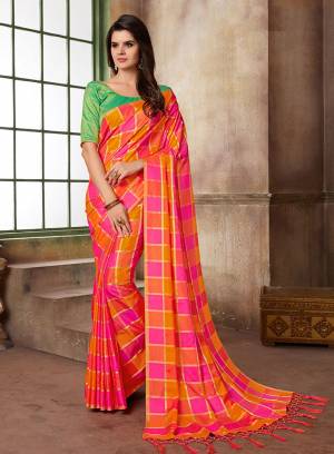 Look Attractive Draping This Lovely Pink And Orange Colored Saree Paired With Contrasting Green Colored Blouse. This Saree And Blouse Are Silk Based With Checks Prints All Over. 