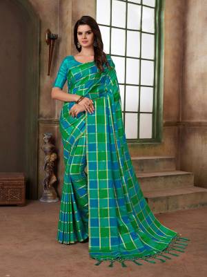 Look Attractive Draping This Lovely Blue And Green Colored Saree Paired With Contrasting Green Colored Blouse. This Saree And Blouse Are Silk Based With Checks Prints All Over. 