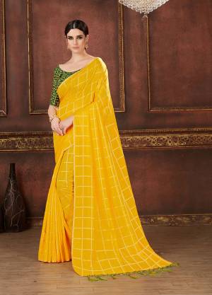 Celebrate This Festive Season Wearing This Beautiful Designer Checks Printed Saree In Yellow Color Paired With Dark Green Colored Blouse. This Saree And Blouse Are Silk Based Which Also Gives A Rich Look To Your Personality. 