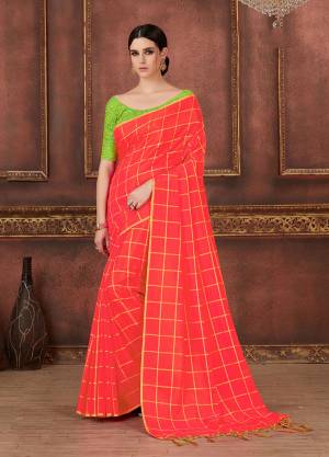 Here Is A Pretty Bright Shade With This Saree In Dark Peach Color Paired With Contrasting Light Green Colored Blouse. This Saree And Blouse are Silk based Beautified With Prints, Embroidery And Tassels. It Is Light Weight And Having A Very Trendy Checks Pattern.