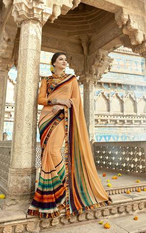 For Your Semi-Casuals, Grab This Pretty Saree In Peach Color Paired With Multi Colored Blouse. This Saree Is Fabricated On Georgette Paired With Art Silk And Net Fabricated Blouse. It Is Beautified With Prints And Lace Border. 