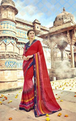 Celebrate This Festive Season Wearing This Attractive Looking Red Colored Saree Paired With Navy Blue Colored Blouse. This Printed Saree Is Georgette Based Paired With Art Silk And Net Fabricated Blouse. 
