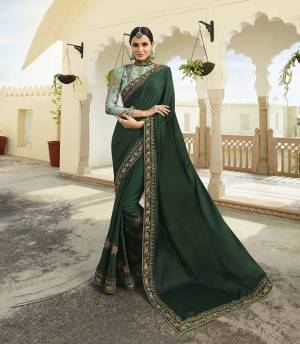 Go With The Shades Of Green with This Designer Saree In Dark Green Color Paired With Light Green Colored Blouse. This Saree And Blouse Are Silk Based Beautified With Heavy Embroidery. 