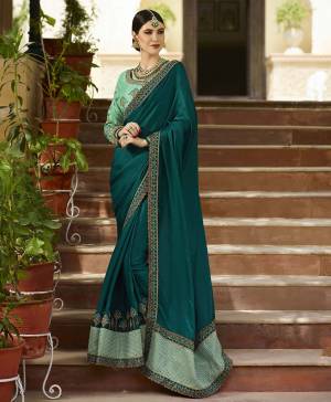 Pretty Unique Shade Is Here To Add Into Your Wardrobe With This Designer Saree In Teal Blue Color Paired With Contrasting Sea Green Colored Blouse. This Saree And Blouse Are Silk Based Beautified With Heavy Embroidery Over The Blouse And Saree Border. 