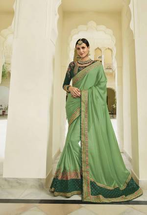 Go With The Shades Of Green with This Designer Saree In Light Green Color Paired With Dark Green Colored Blouse. This Saree And Blouse Are Silk Based Beautified With Heavy Embroidery. 