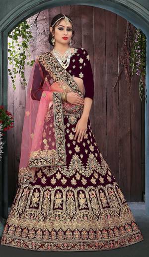 Get Ready For Your Big Day With This Heavy Designer Lehenga Choli?In Wine  Paired With Pink Colored Dupatta. This Heavy Embroidered Lehenga Choli Is Fabricated On Velvet Paired With Net Fabricated Dupatta. It Is Beautified With Heavy Jari Embroidery and Stone Work. Buy Now