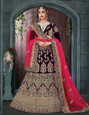 Get Ready For Your Big Day With This Heavy Designer Lehenga Choli?In Dark Wine  Paired With Fuschia Pink Colored Dupatta. This Heavy Embroidered Lehenga Choli Is Fabricated On Velvet Paired With Net Fabricated Dupatta. It Is Beautified With Heavy Jari Embroidery and Stone Work. Buy Now
