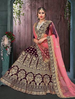 Here Is A Perfect Bridal Look For You With This Heavy designer Lehenga Choli In Dark Wine Color Paired With Peach Colored Dupatta. This Lehenga Choli Is Velvet Based Paired With Net Fabricated Dupatta.Its Fabric Also Ensures Superb Comfort Throughout The Gala.