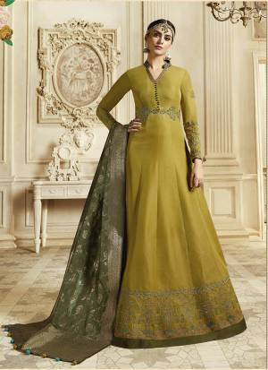 Celebrate This Festive And Wedding Season Wearing This Designer Floor Length Suit In Musturd Yellow Color Paired With Contrasting Olive Green Colored Dupatta. Its Top Is Fabricated On Soft Silk Paired With Santoon Bottom And Banarasi Art Silk Dupatta. Buy Now.