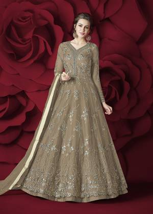 Flaunt Your Rich and Elegant Taste Wearing This Designer Floor Length Suit In Beige Colored Top Paired With Beige Colored Bottom And Dupatta. Its Top Is Fabricated On Net Paired With Silk Bottom And Net Dupatta. Its Rich and Elegant Embroidery Will Earn Your Lots Of Compliments From Onlookers.