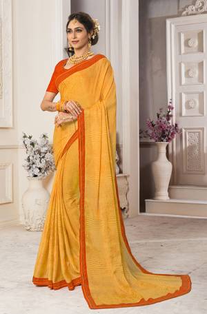 Celebrate This Festive In Traditional Color Pallete With This Saree In Yellow Color Paired With Contrasting Orange Colored Blouse. This Saree Is Fabricated On Georgette Chiffon Paired With Art Silk Fabricated Blouse.  