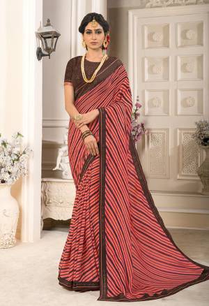 Adorn The Pretty Angelic Look In This Peach Colored Saree Paired With Contrasting Brown Colored Blouse. This Saree Is Fabricated On Georgette Chiffon Paired With Art Silk Fabricated Blouse. It Is Beautified With Prints And Stone Work. 
