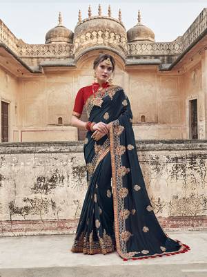 Enhance Your Personality Wearing This Designer Saree In Navy Blue Color Paired With Contrasting Red Colored Blouse, This Saree And Blouse Are Fabricated On Art Silk Beautified With Contrasting Embroidery Giving It An Attractive Look.