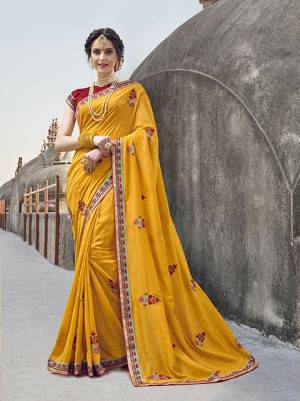 Celebrate This Festive Season Wearing This Designer Saree In Yellow Color Paired With Contrasting Red Colored Blouse. This Lovely Saree Ans Blouse Are Silk Based Which Gives A Rich Look To Your Personality. 
