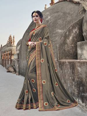 Flaunt Your Rich And Elegant Taste Wearing This Designer Saree In Dark Grey Color Paired With Contrasting Red Colored Blouse. This Saree Is Fabricated On Silk Georgette Paired With Art Silk Blouse. Its Rich Color And Fabric Will Earn You Lots Of Compliments From Onlookers.