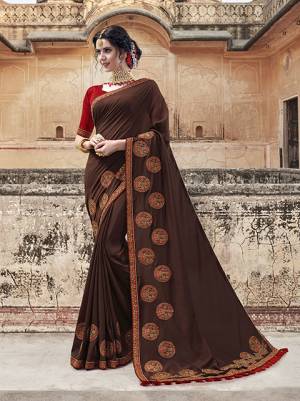 Enhance Your Personality Wearing This Designer Saree In Brown Color Paired With Contrasting Red Colored Blouse, This Saree And Blouse Are Fabricated On Art Silk Beautified With Contrasting Embroidery Giving It An Attractive Look.