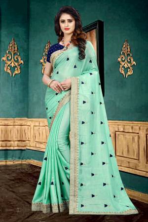 Very Pretty Shade In Here With This Designer Saree In Turquoise Blue Color Paired With Navy Blue Colored Blouse. This Saree Is Fabricated On Georgette Paired With Brocade Fabricated Blouse. It Has Pretty Butti Work All Over It With Embroidered Lace Border. 