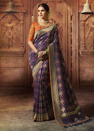 Shine Bright In This Very Beautiful And Attractive Looking Heavy Designer Saree In Purple Color Paired With Contrasting Orange colored Blouse. This Silk Based Saree Is Beautified With Detailed Weave And Heavy Embroidery. Buy This Saree Now.