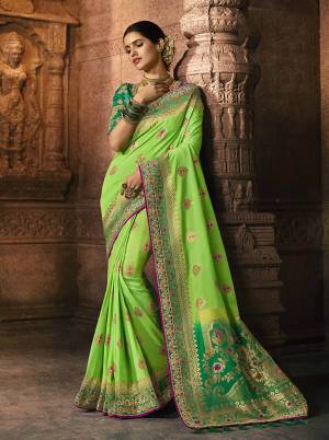 Go With The Lovely Shades Of Green In This Beautiful And Heavy Designer Saree In Parrot Green Color Paired With Green Colored Blouse. This Saree And Blouse Are Silk Based Beautified With Weave And Embroidery. 