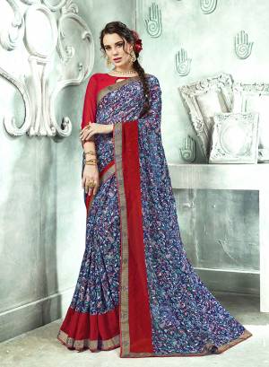 Bright And Appealing Color Is Here With This Saree In Blue Color Paired With Red Colored Blouse. This Saree And Blouse are Georgette Based Beautified With Prints And Lace Border. Its Fabrics Ensures Superb Comfort All Day Long. 