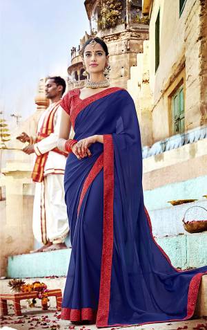 Celebrate This Festive Season Wearing This Designer Saree In Royal Blue Color Paired With Red Colored Blouse. This Saree Is Georgette Based Paired With Art Silk Fabricated Embroidered Blouse. Buy Now.