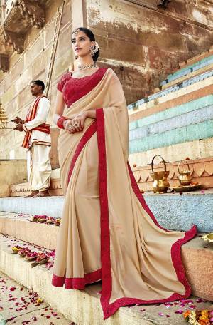 Adorn The Pretty Angelic Look Wearing This Designer Saree In Cream Color Paired With Red Colored Blouse. This Saree Is Georgette Based Paired With Art Silk Fabricated Blouse. It Is Beautified With Embroidery Over The Blouse And Saree Lace Border.
