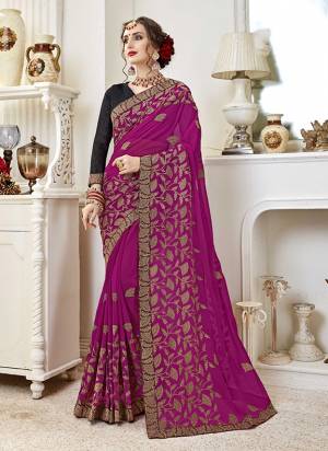 Adorn The Pretty Angelic Look Wearing This Heavy Designer Saree In Rani Pink Color Paired With Black Colored Blouse. This Saree Is Fabricated On Georgette Paired With Art Silk Fabricated Blouse. It Is Beautified With Heavy Embroidery All Over. 