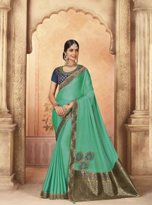 Here Is A Very Pretty Designer Saree In Turquoise Blue Color Paired With Navy Blue Colored Blouse. This Saree And Blouse Are Fabricated On Art Silk Beautified Prints And Embroidery. Buy Now.