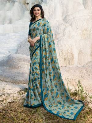 Grab This Very Pretty Floral Printed Saree In Light Blue Color Paired With Teal Blue Colored Blouse. This Saree Is Fabricated On Georgette Paired With Art silk Fabricated Blouse. 
