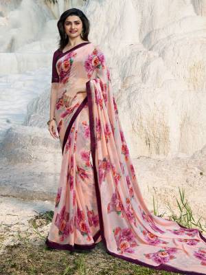 Here Is A Very Pretty Floral Printed Saree In Baby Pink Color Paired With Wine Colored Blouse. This Saree Is Fabricated On Georgette Paired With Art Silk Fabricated Blouse. It Is Beautified With Prints And Lace Border. 