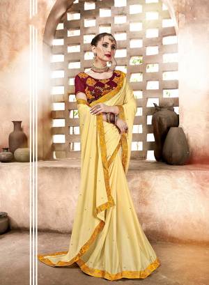 Proper Traditional Color Pallete Is Here For The Upcoming Festive Season. This Saree Is In Light Yellow Color Paired With Contrasting Maroon Colored Blouse. This Saree Is Fabricated On Satin Georgette Paired With Art Silk Fabricated Embroidered Blouse. 