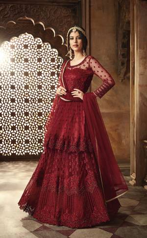 For A Royal Look, Grab This Heavy Designer Floor Length Suit With Double Layered Pattern. Its Rich Maroon Color Will Give A Royal Look To Your Personality. Its Top And Dupatta Are Net Based Paired With Santoon Bottom Also Which IS Having A Satin Inner With Can Can Attached. Its Top Is Beautified With Heavy Resham Embroidery And Moti Hand Work. Buy Now.