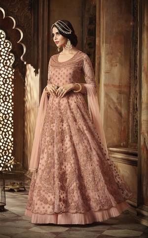 Look Pretty Wearing This Designer Floor Length Suit In Very Pretty Dusty Pink Color. Its Pretty Color Will Definitely Earn You Lots Of Compliments From Onlookers. Its Top And Dupatta Are Net Based Paired With Santoon Bottom. 