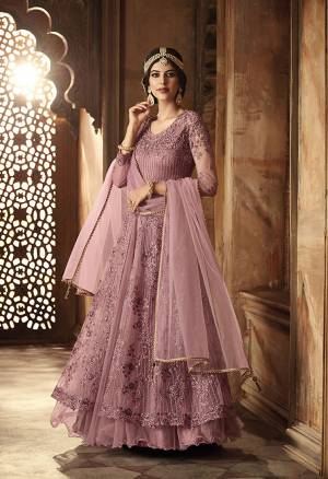 New Shade Is Here To Add Into Your Wardrobe For The Upcoming Wedding Season. Grab This Designer Floor Length Suit In Mauve Color. Its Top And Dupatta Are Net fabricated Paired With Santoon Bottom. Also It Has Satin Inner With Can Can Attacthed. Buy Now.