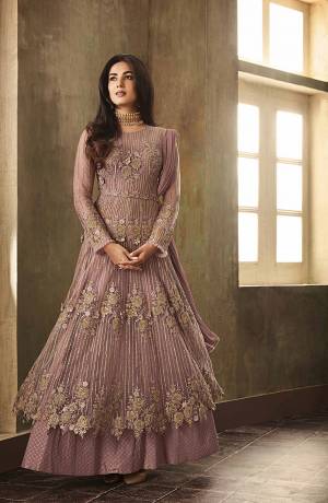 A Must Have Shade In Every Womens Wardrobe Is Here Which Is In Great Run NowDays. This Beautiful Mauve Colored Designer Floor Length Suit Fabricated On Net Paired With Santoon Bottom And Chiffon Dupatta. It Is Beautified With Heavy Embroidery All Over The Top. Buy Now.
