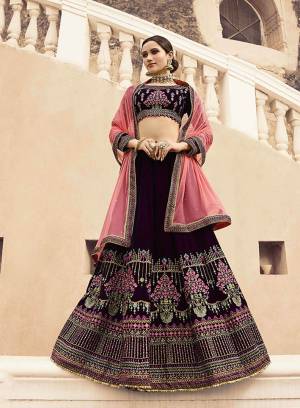 For A Designer And Unique Look, Grab This Heavy Deisgner Lehenga Choli With Jacekt. This Lehenga Choli Is In Dark Wine Color Paired With Baby Pink Colored Dupatta And Jacket. Its Blouse And Lehenga Are Vekvet Based Paired With Net Fabricated Dupatta And Art Silk Jacket. 