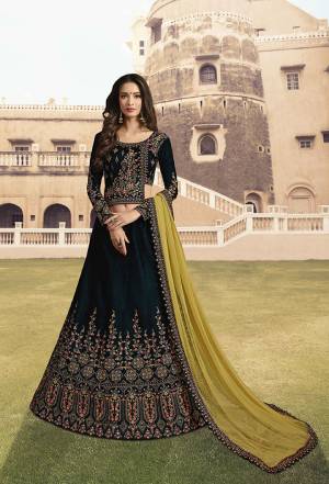 Catch All The Lime Light This Wedding Season Wearing This Heavy Designer Lehenga Choli In Dark Teal Green Color Paired With Pear Green Colored Dupatta. Its Blouse And Lehenga Are Fabricated On Velvet Paired With A Net Fabricated Dupatta. Buy Now.
