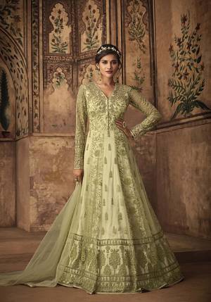 This Festive Season, Be The Most Trendy Amongst All wearing This Heavy Designer Floor Length Suit In Light Green color. Its Top IS Fabricated On Net Beautified With Heavy Thread And Coding Embroidery Paired With Satin Bottom And Net Fabricated Dupatta. 