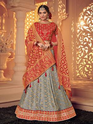 marvelously charming is what you will look at the next wedding gala wearing this beautiful Red And Grey color jacquard fabrics and satin lehenga. Ideal for party, festive & social gatherings. this gorgeous lehenga featuring a beautiful mix of designs. Its attractive color and designer heavy embroidered lehenga with jacquard dupatta and fancy blouse, stone design, beautiful floral design work over the attire & contrast hemline adds to the look. Comes along with a contrast unstitched blouse.