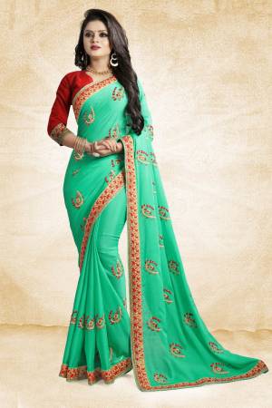 Celebrate This Festive Season With Beauty And Comfort Wearing This Designer Saree In Sea Green Color Paired With Contrasting Red Colored Blouse. This Saree And Blouse Are Silk Based Beautified With Embroidered Butti All Over It. It Is Easy to Drape And Durable. 