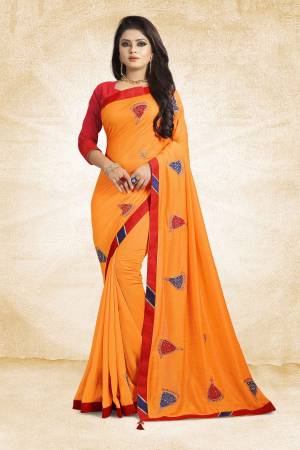 For Your Semi-Casuals, Add This Bright Saffron Colored Designer Saree To Your Wardrobe Paired With Red Colored Blouse. This Saree And Blouse Are Silk Based Beautified With Simple Butti Work. Grab It Now.