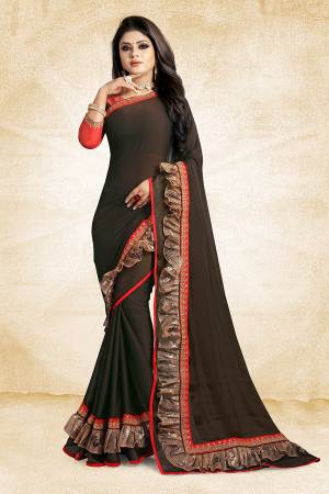 Celebrate This Festive Season With Beauty And Comfort Wearing This Designer Saree In Dark Brown Color Paired With Contrasting Red Colored Blouse. This Saree Is Fabricated On Georgette Paired With Art Silk Fabricated Blouse. It Has Fancy Lace Border Giving It An Attractive Look. 