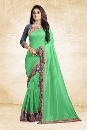 Look Pretty Wearing This Designer Silk Based Saree In Green Color Paired With Grey Colored Blouse. This Saree And Blouse Are Silk Based Beautified With Lace Border And Printed Frill Over The Border. Buy This Pretty Saree Now.