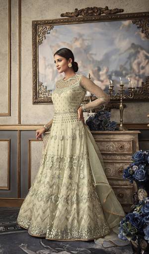 Simple And Elegant Looking Heavy Designer Floor Length Suit Is Here In Off-White Color Paired With Off-White Colored Bottom And Dupatta. Its Heavy Embroidered Top Is Fabricated On Net Paired With Art Silk Bottom And Net Fabricated Dupatta. Buy This Designer Suit Now.