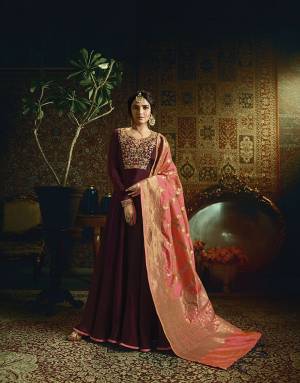 For A Royal look, Grab This Designer Floor Length Suit In Maroon Color Paired With contrasting Dark Peach Colored Dupatta, Its Top Is Fabricated On Satin Georgette Paired With Santoon Bottom And Banarasi Silk Dupatta. All Its Fabrics Ensures Superb Comfort All Day Long. 