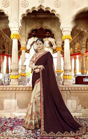 Adorn The Pretty Angelic Look wearing This Designer Saree In Brown Color Paired With Cream Colored Blouse. This Saree Is Fabricated On Soft Silk Paired With Art Silk And Net Fabricated Blouse. It Is Beautified With Heavy Embroidery Over The Saree And Blouse. 