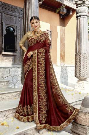 For A Royal Look, Grab This Heavy Designer Saree In Maroon Color Paired With Golden Colored Blouse. This Saree And Blouse Are Silk Based With Attractive Embroidery. Its Royal Color Pallete And Rich Fabric Will Earn You Lots Of Compliments From Onlookers. 
