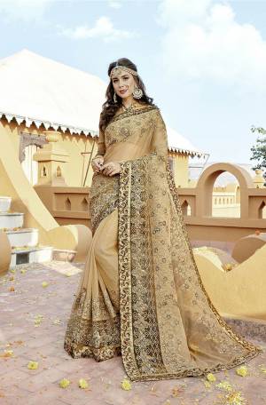 Flaunt Your Rich And Elegant Taste Wearing This Designer Saree In Beige Color Paired With Golden Colored Blouse. This Saree Is Fabricated On Orgenza Paired With Art Silk Fabricated Blouse. It Has Heavy Embroidery Which Earns You Lots Of Compliments From Onlookers. 
