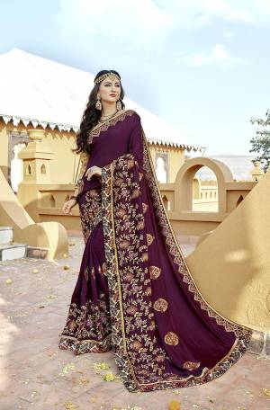 A Must Have Shade In Every Womens Wardrobe Is Here With This Designer Saree In Wine Color Paired With Golden Colored Blouse. This Saree And Blouse Are Silk Based Beautified With Embroidery All Over. 
